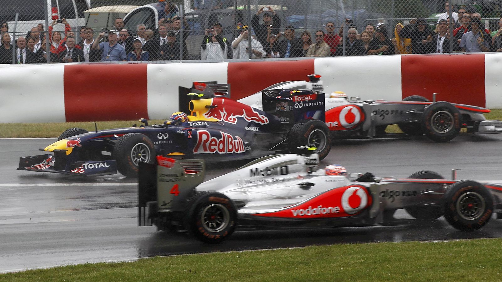 Imagen del GP de Canadá, con Mark Webber dando un trompo entre los coches de Lewis Hamilton, al fondo, y Jenson Button, en primer plazo.