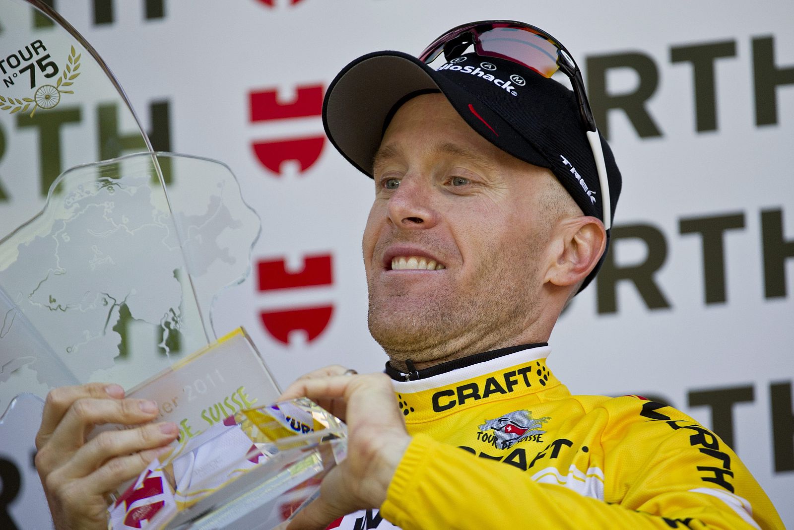 El estadounidense Levi Leipheimer celebra en el podio al ganar la Vuelta a Suiza tras arrebatar por tan solo cuatro segundos el jersey amarillo al italiano Damiano Cunego.