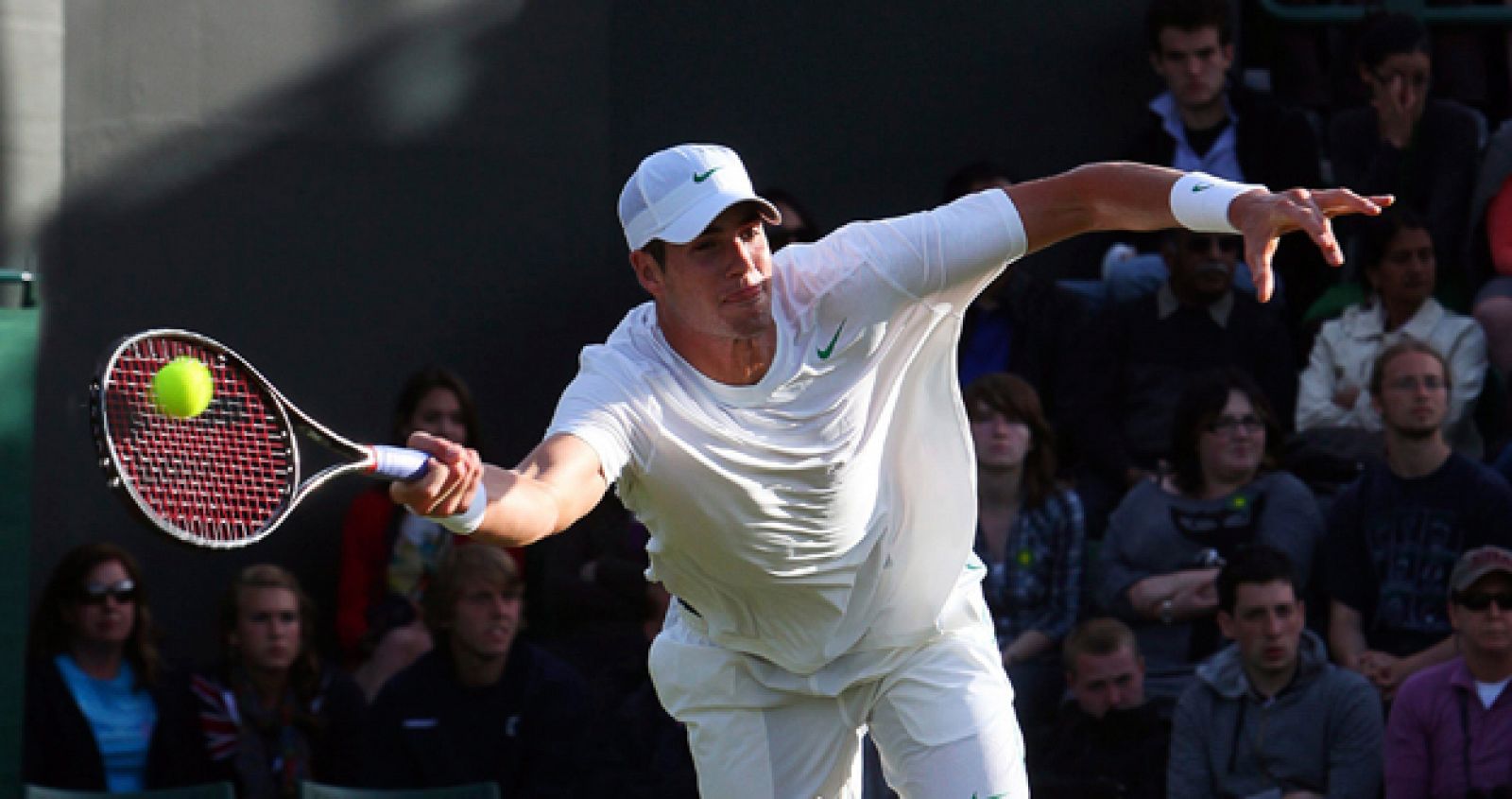 El tenista norteamericano John Isner devuelve la bola al francés Nicolas Mahut, durante el primer partido de ronda del torneo de tenis de Wimbledon.