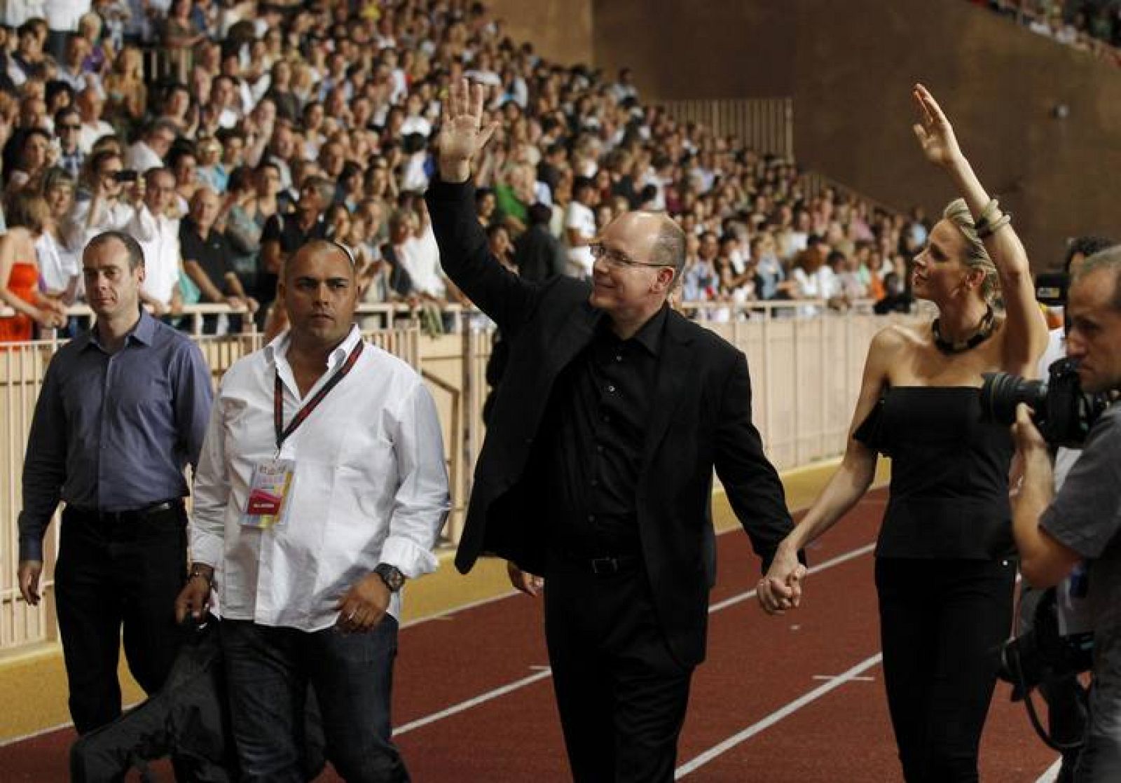 El príncipe Aberto II y su prometida saludan a su llegada al concierto de The Eagles