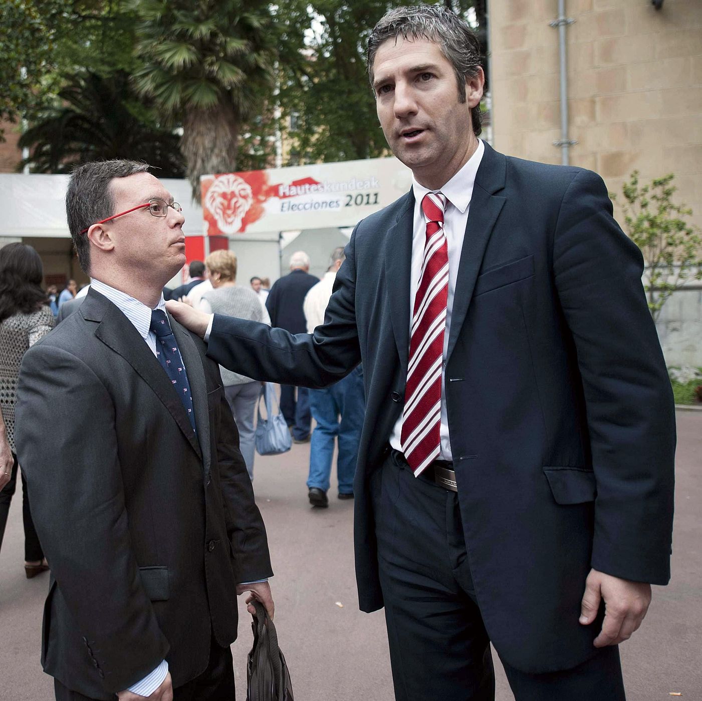 El candidato a la Presidencia del Club Athletic de Bilbao Josu Urrutia (d) junto a un socio del club, hoy en las inmediaciones del Palacio de Ibagane, la sede social del Athletic.