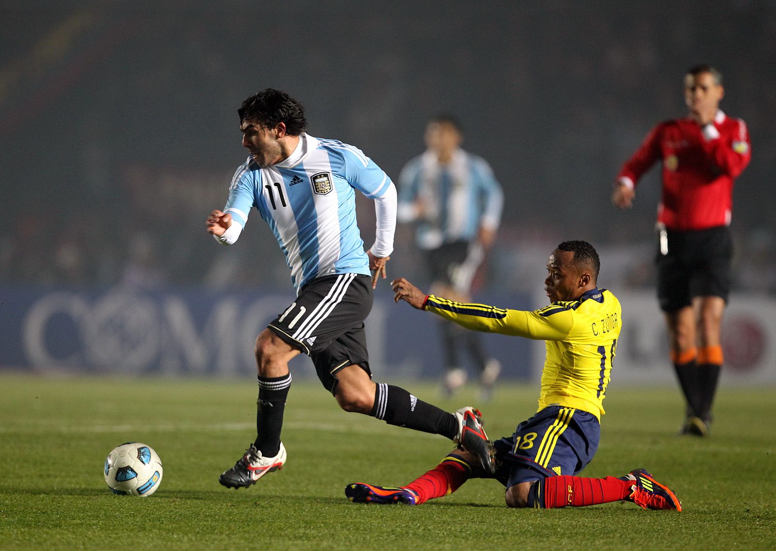 El jugador de la selección de Argentina de fútbol Carlos Tévez (izq) disputa el balón durante un partido de la segunda jornada del grupo A de la Copa América Argentina 2011