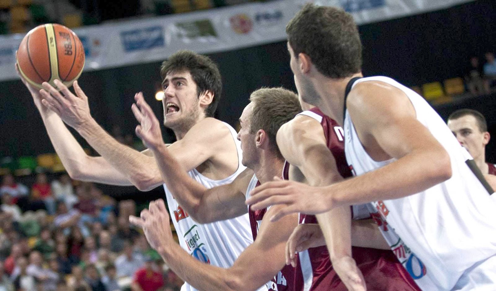 El jugador de la selección española de baloncesto Joan Sastre captura un balón ante la defensa de Letonia.