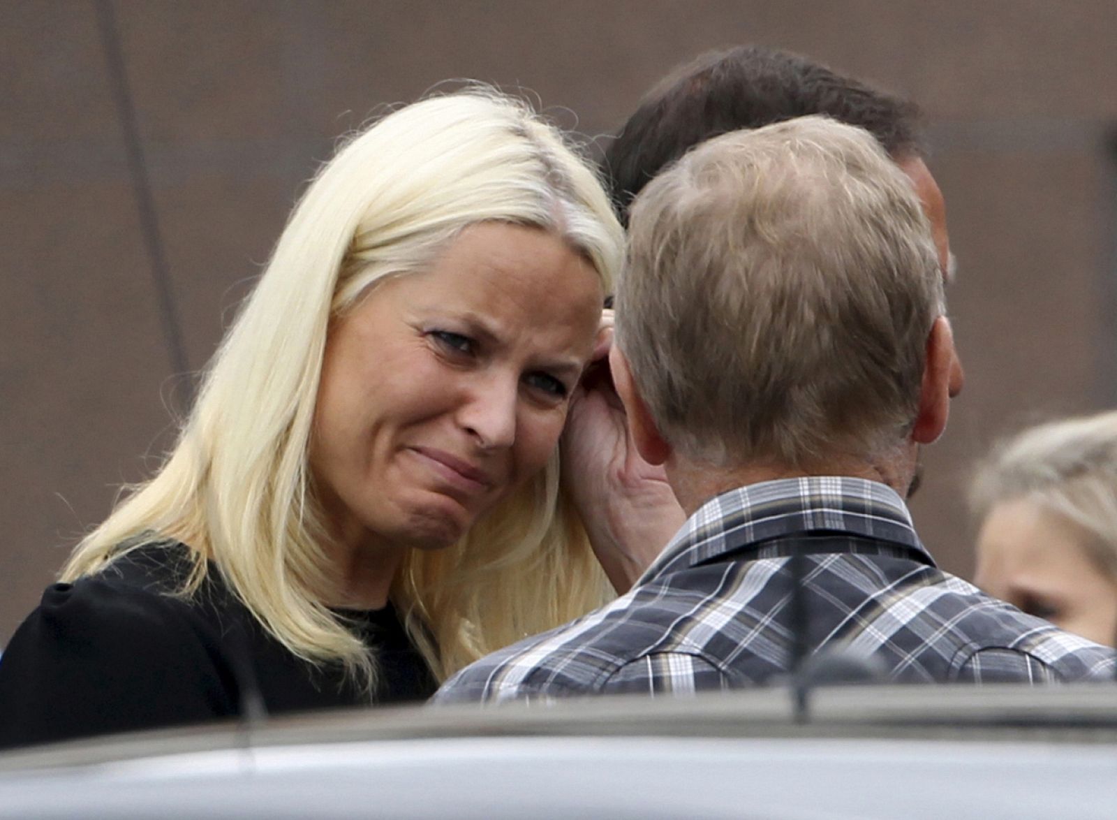 Norway's Crown Princess Mette Marit reacts as she talks with relatives of the victims of a rampage on nearby Utoeya island after a memorial service at a church in Sundvollen