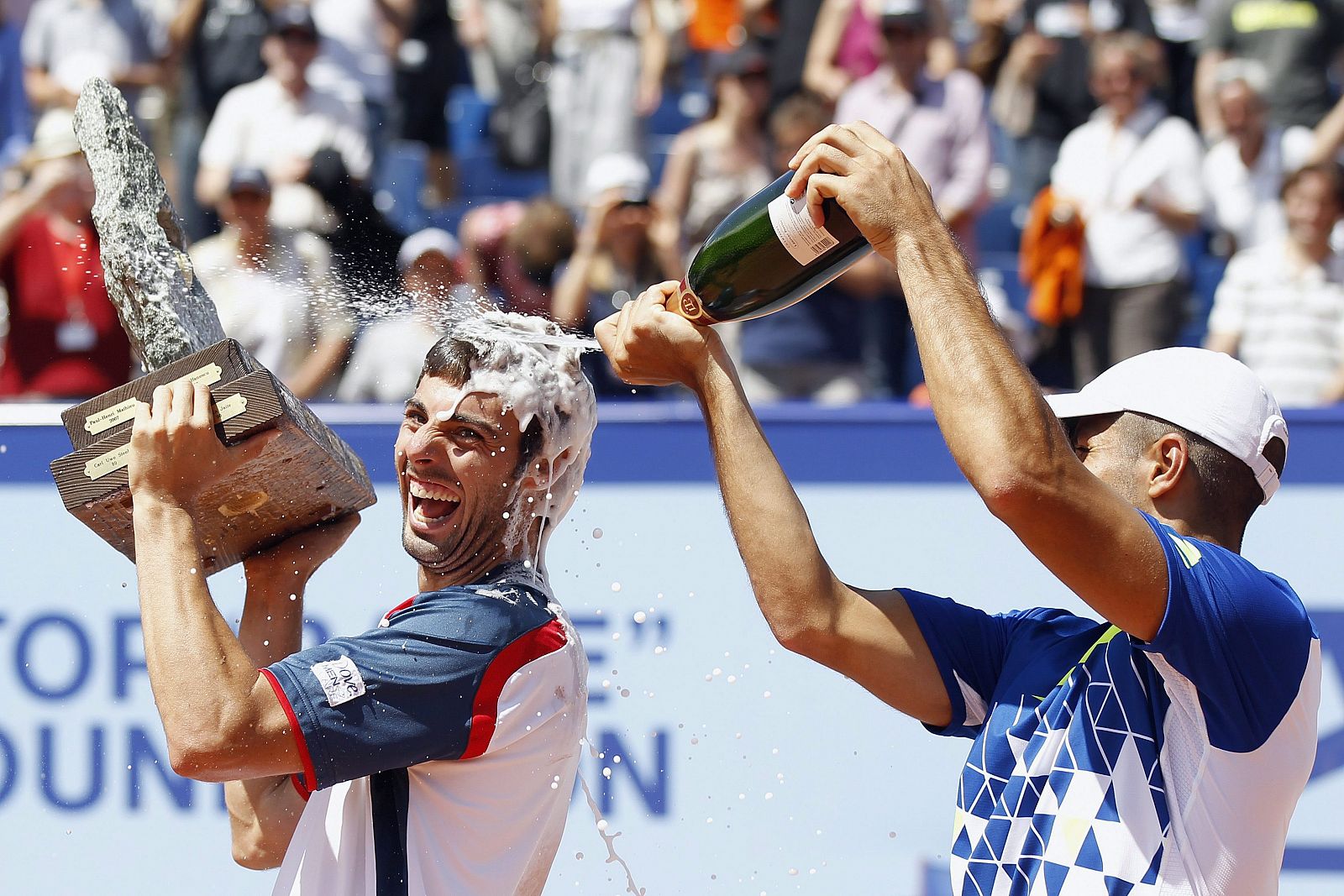 Marcel Granollers (izq) es rociado con champán por su compatriota y contrincante Fernando Verdasco (dcha).