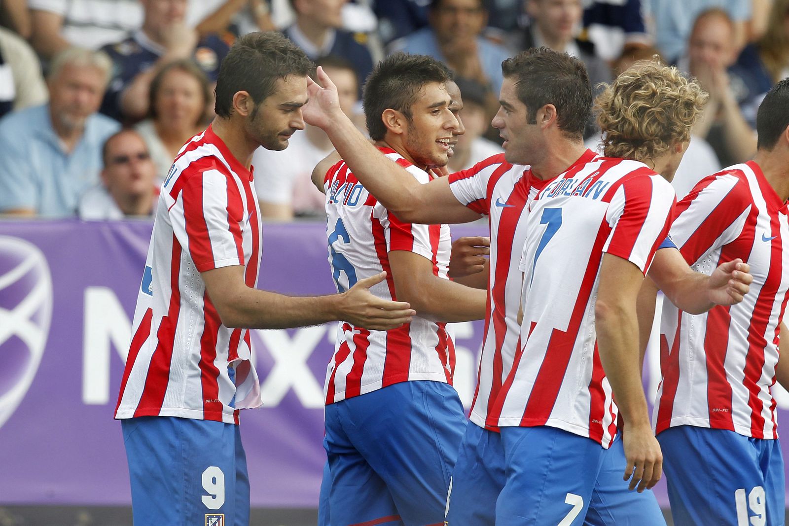 Adrian Lopez (a la izquierda) del Atlético de Madrid, recibe la felicitación de sus compañeros