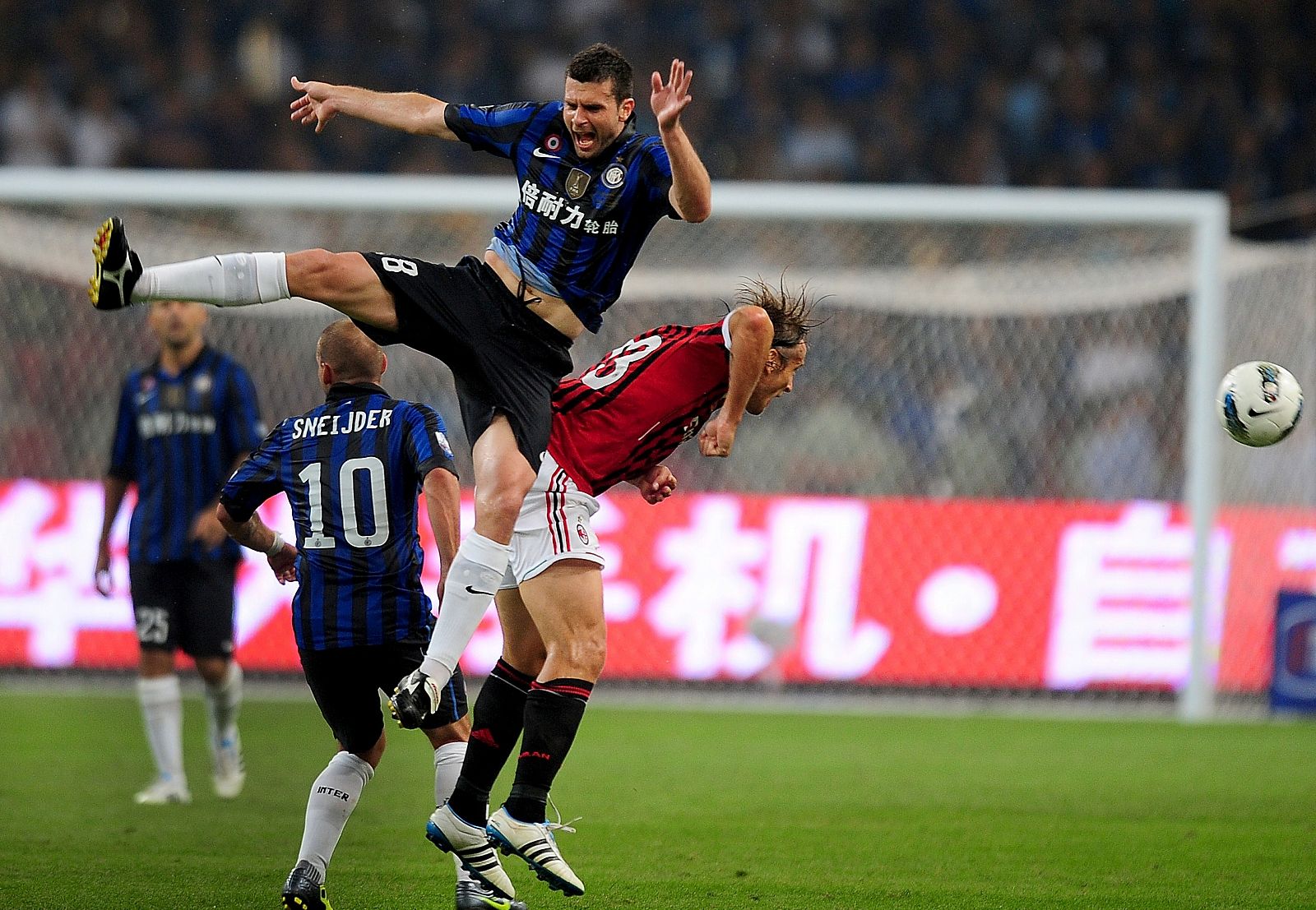 Massimo Ambrosini del AC Milan lucha un balón con Thiago Motta del Inter de Milán en el partido de la Supercopa italaiana