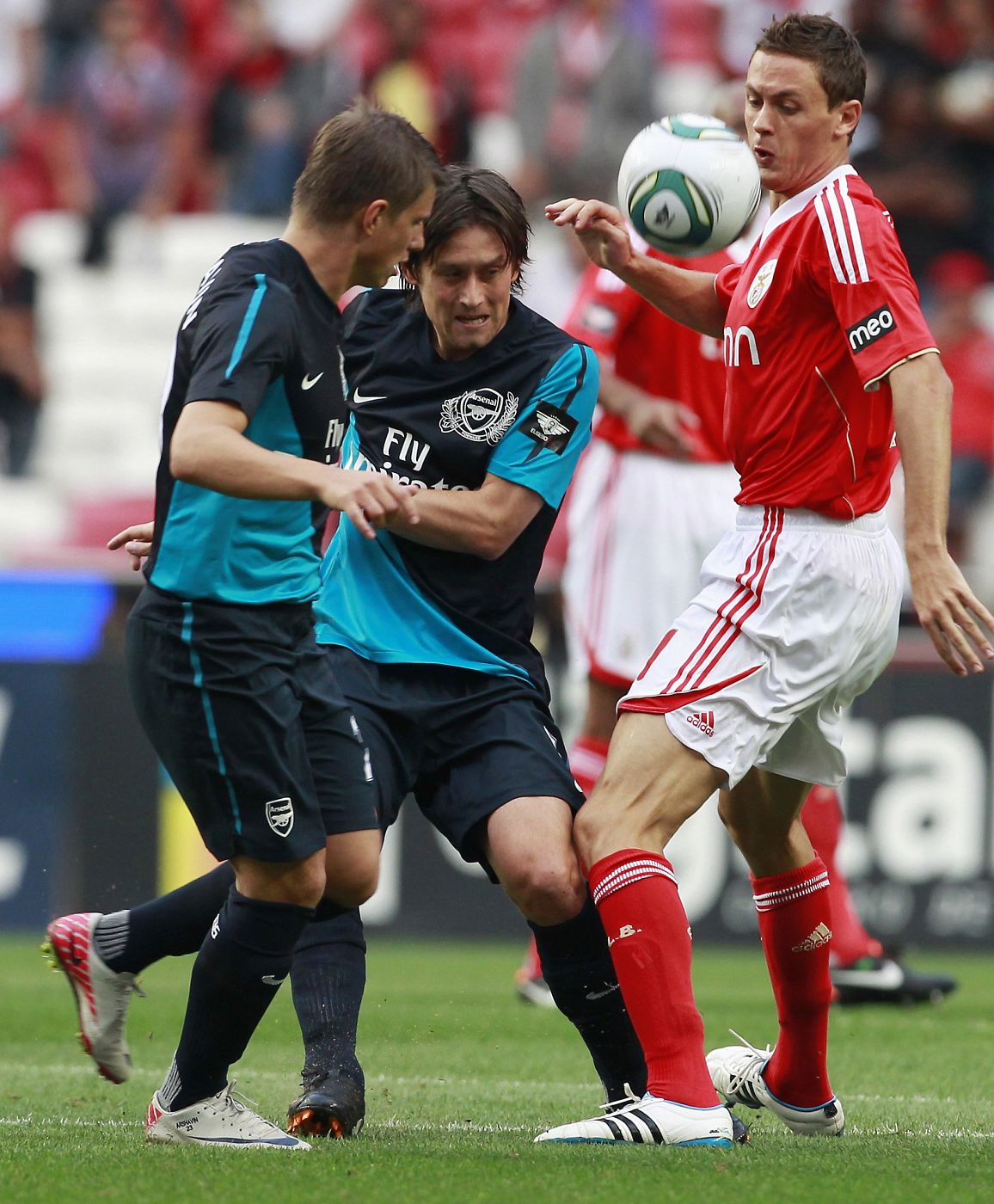 Benfica's Matic fights for the ball with Arsenal's Arshavin and Rosicky during their Eusebio Cup soccer match at Luz stadium in Lisbon