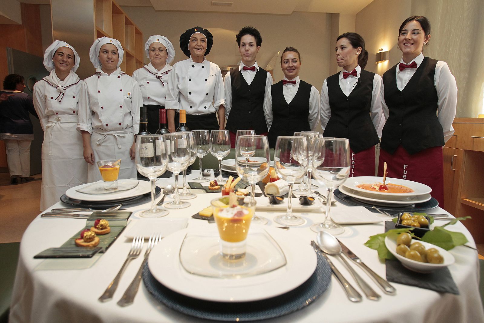 Cocineras y camareras de la Escuela de Hostelería Fuenllana, ante varios de los platos que el Papa degustará en la JMJ