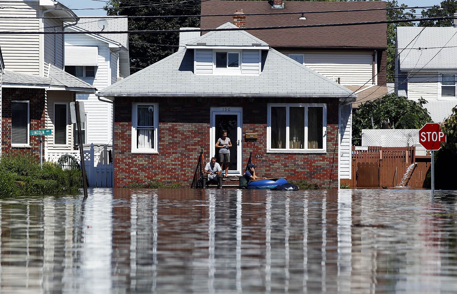 Dos habitantes de Totowa, Nueva Jersey, esperan a que bajen las aguas tras la inundación causada por el "Irene"
