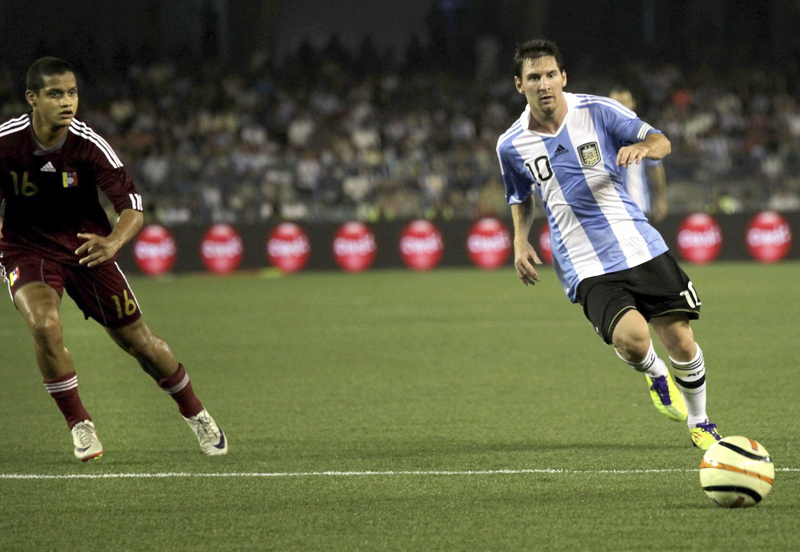 El futbolista argentino Lionel Messi (der) y el venezolano Roberto Rosales durante el partido amistoso