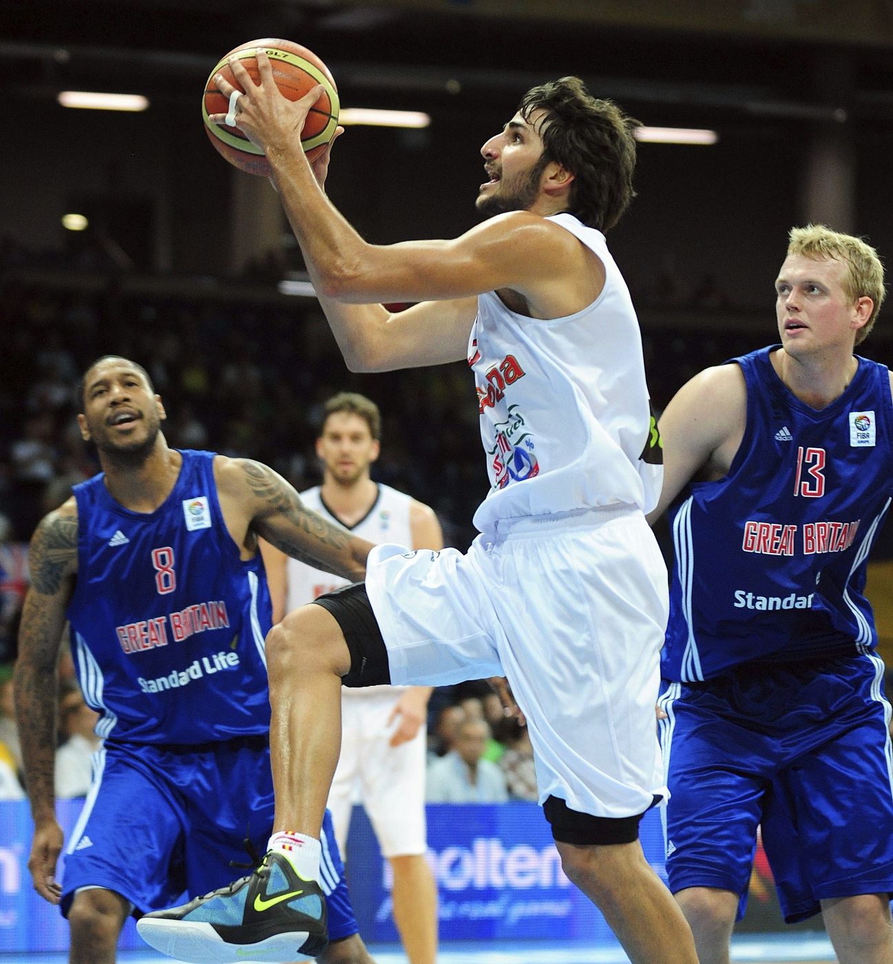 Ricky Rubio intenta encestar ante la mirada de los jugadores británicos, Sullivan (i) y Clark (d)