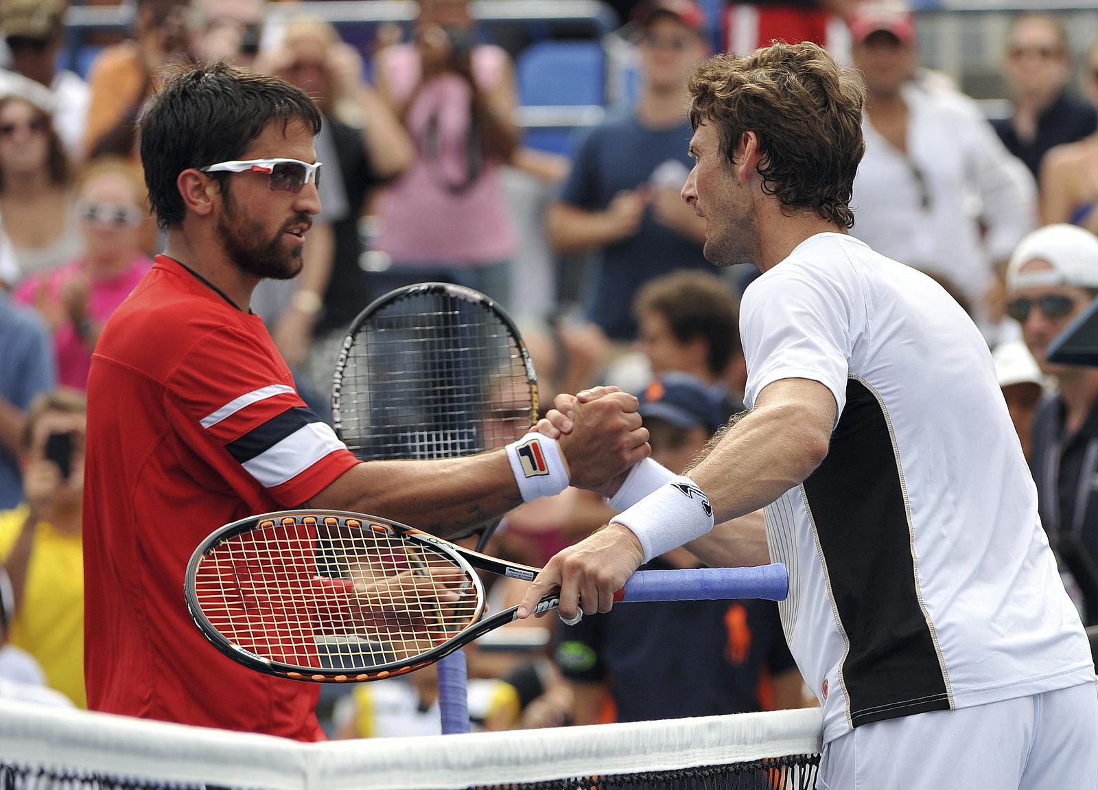 El tenista serbio Janko Tipsarevic (izda) saluda al español Juan Carlos Ferrero, tras vencerle en el partido de cuarta ronda del Abierto de Estados Unidos