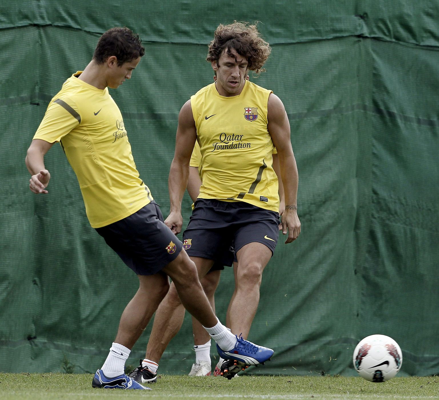 Carles Puyol (d) y el centrocampista holandés, Ibrahim Afellay, durante el entrenamiento