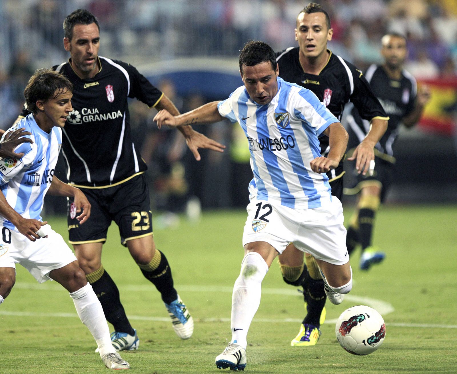 Santi Cazorla conduce el balón ante Yebda y Abel Gómez