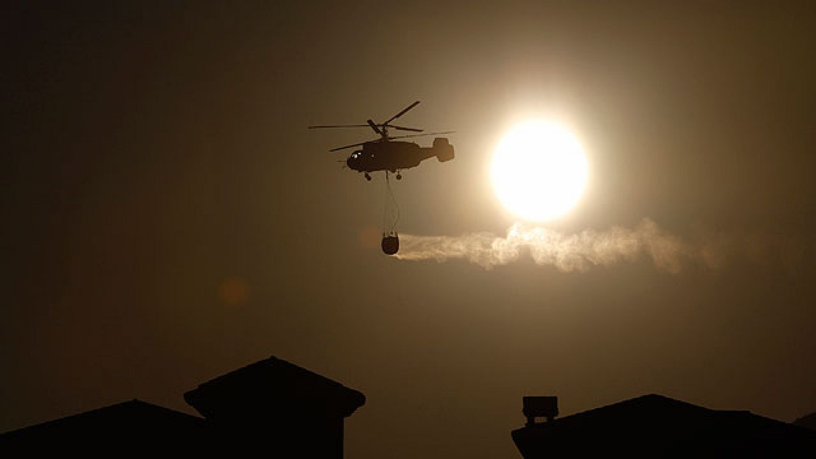 Un helicóptero arroja agua en la extinción del incendio de Mijas