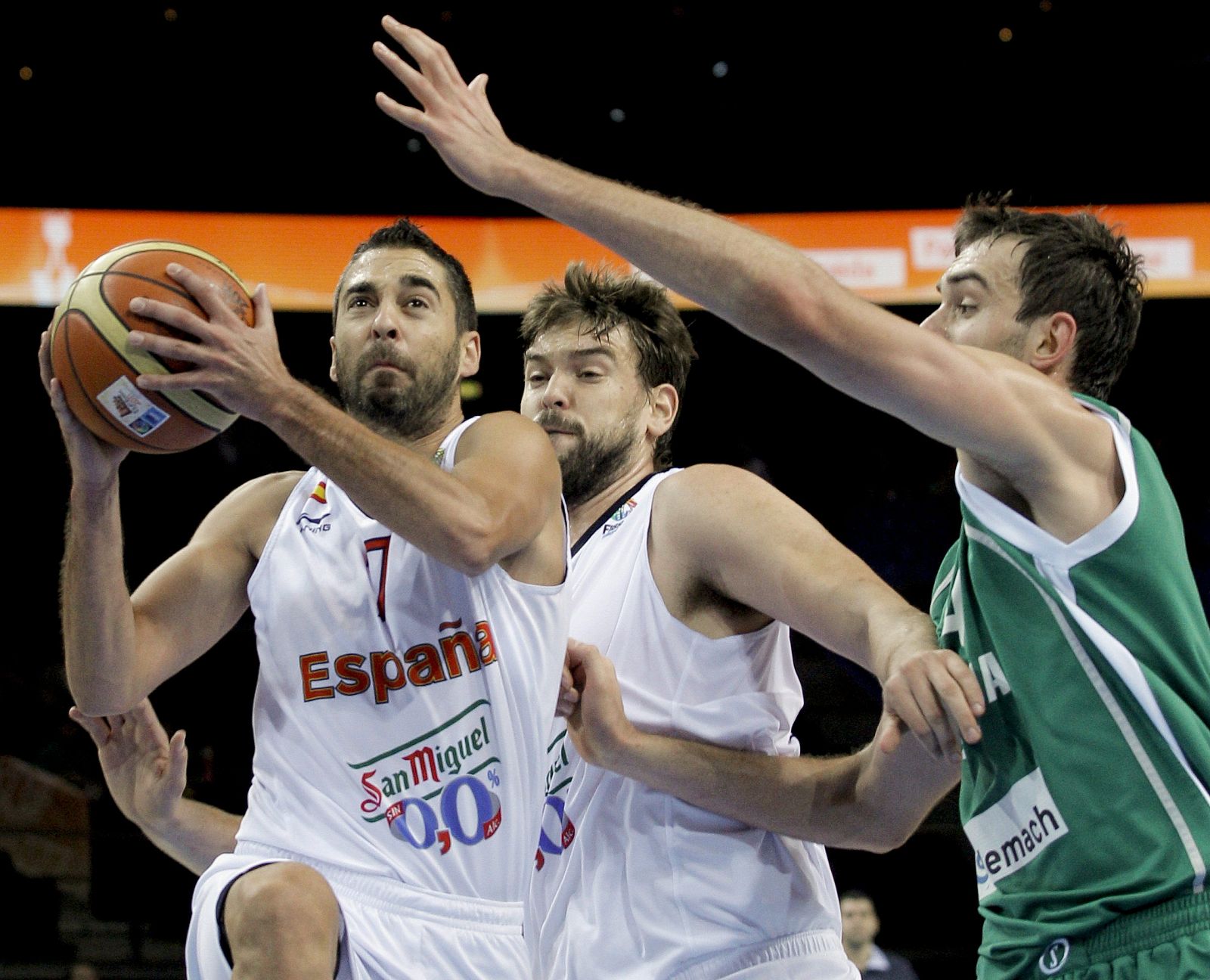 El jugador de la selección española de baloncesto Juan Carlos Navarro (i) entra a canasta ante la defensa del esloveno Mirza Begic (d) y ante la mirada del español Marc Gasol (c) durante el partido de cuartos de final del Eurobasket