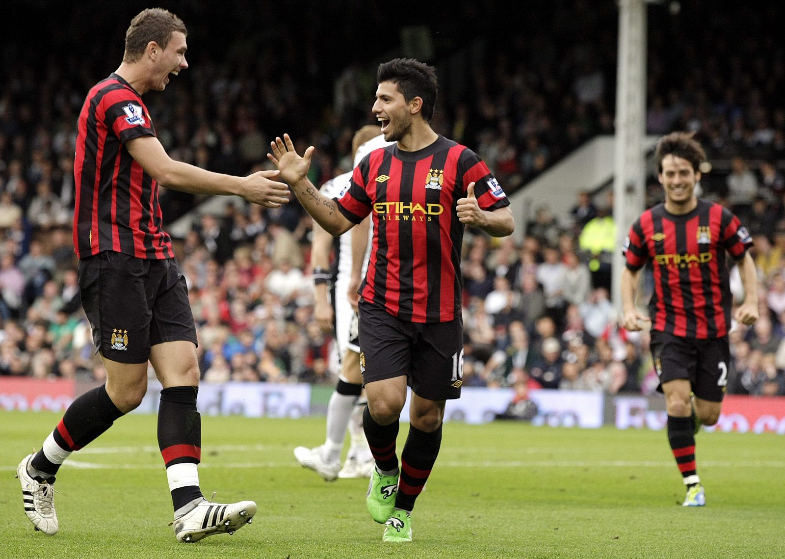 El jugador argentino del Mánchester City Sergio "Kun" Agüero (c), celebra con su compañero Edin Dzeko (i) su segundo gol ante el Fulham