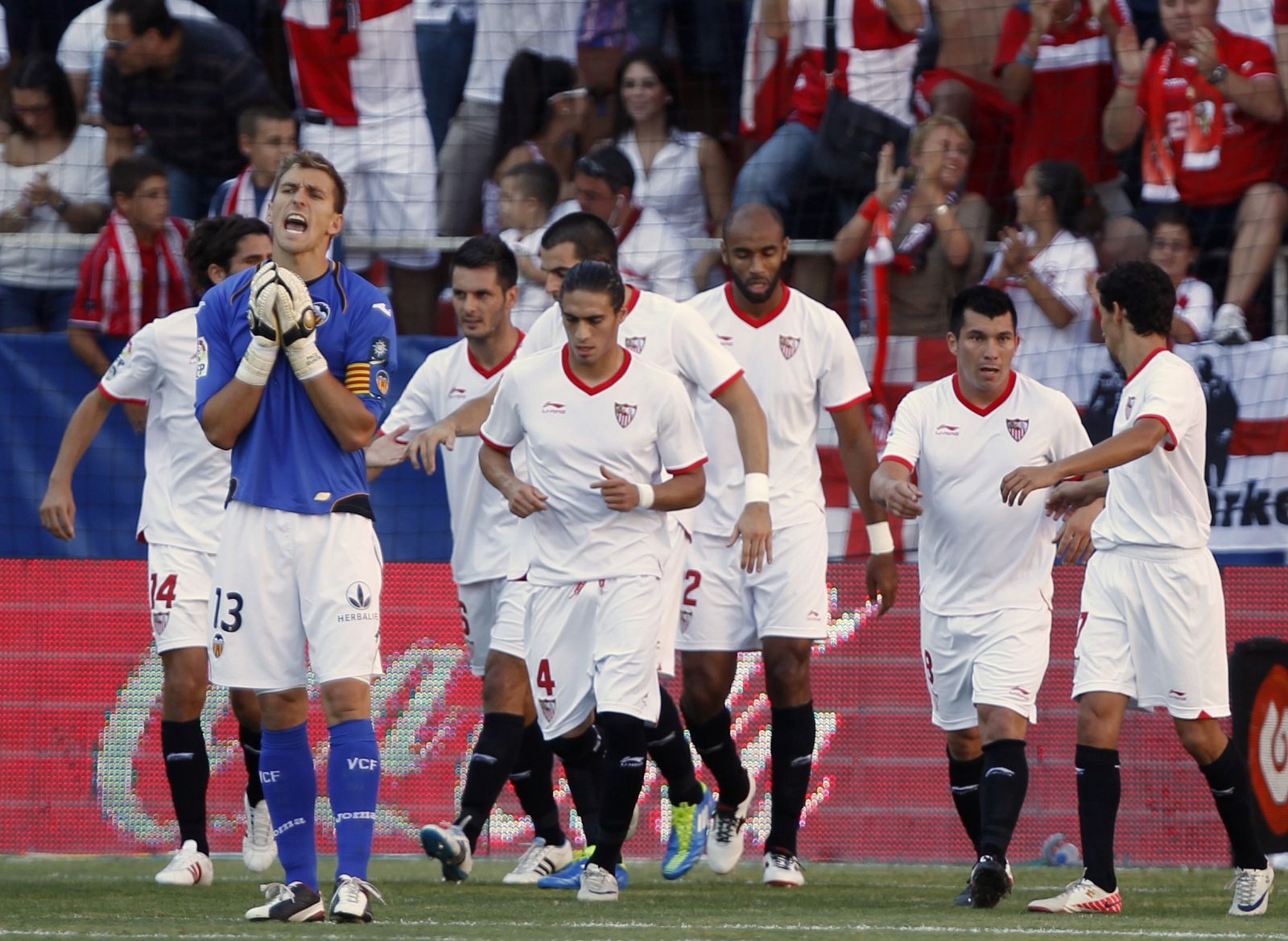 Los jugadores del Sevilla celebran el tanto de Kanoute mientras el portero del Valencia, Guaita, se lamenta