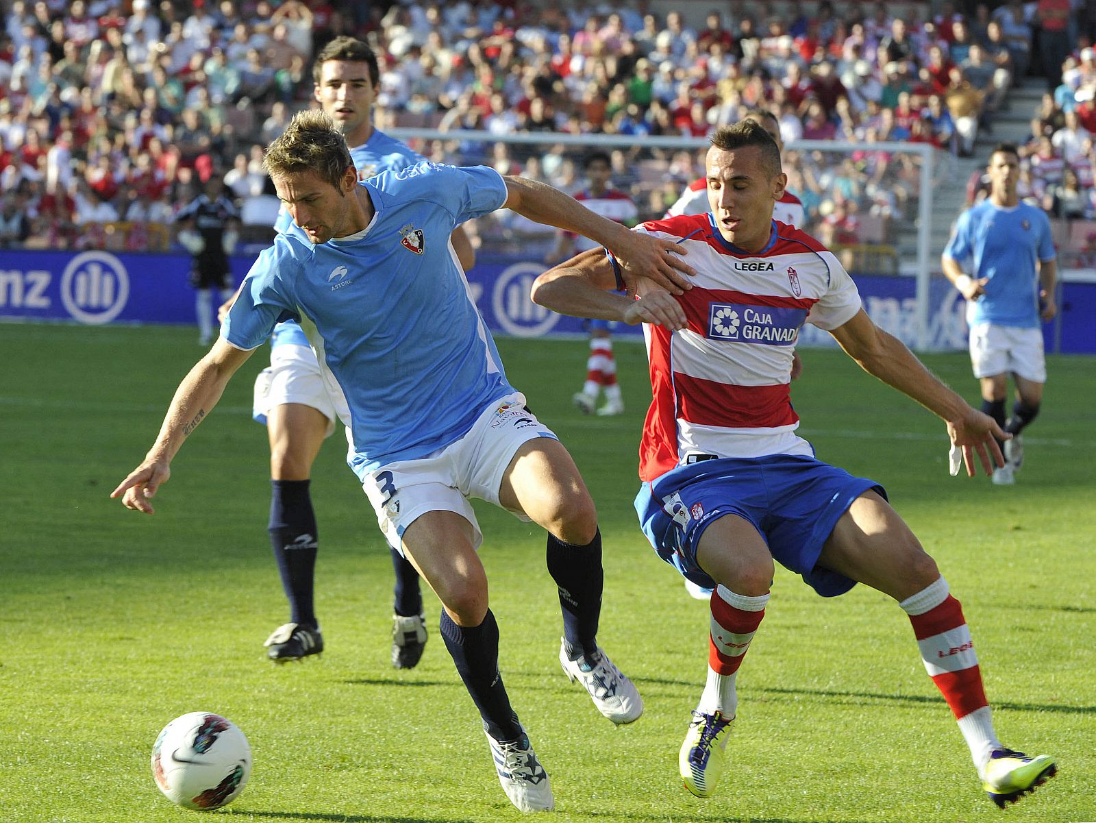 El defensa del Osasuna, Rubén González (i), lucha por el balón con el mediocentro francés del Granada, Hassan Yebda (d)