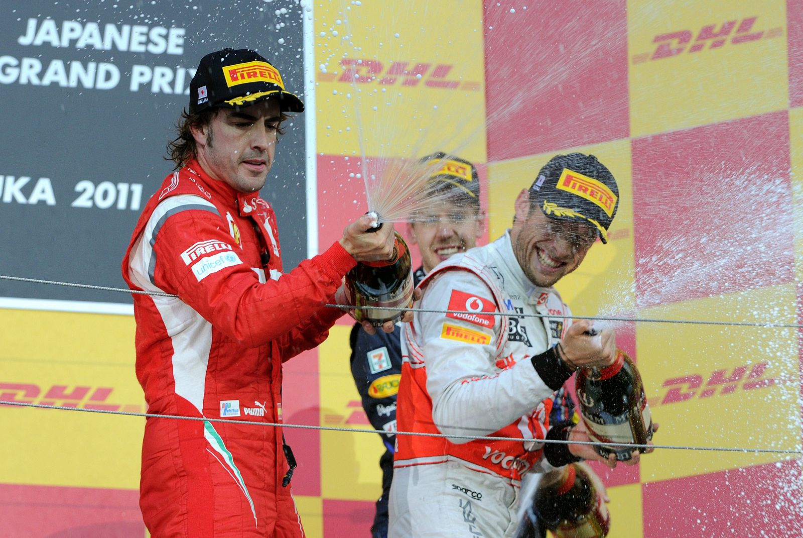 Fernando Alonso celebra su segundo puesto en el podio, con Button y Vettel