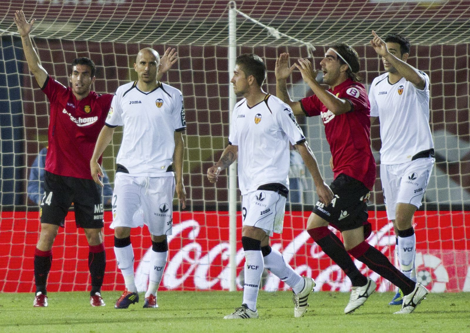 Los jugadores del RCD Mallorca reclaman al árbitro una acción en presencia de los jugadores del Valencia CF.