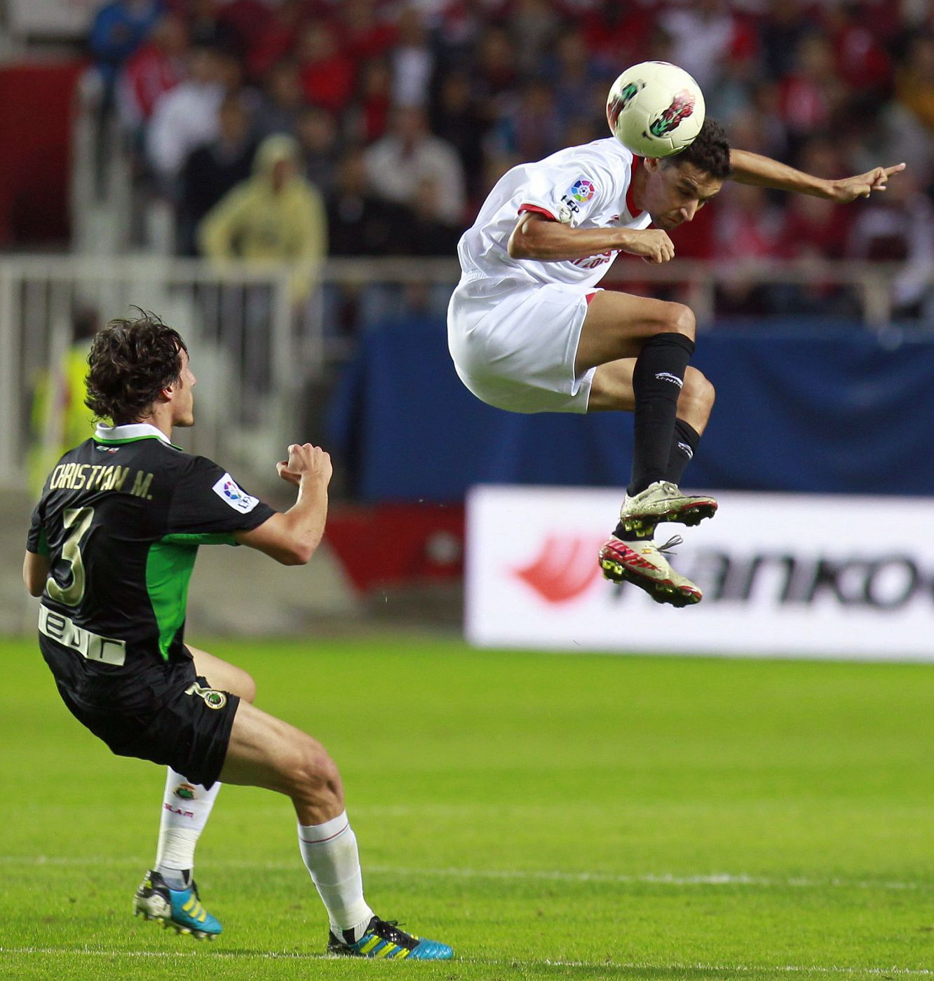 Racing de Santander's Fernandez looks at Sevilla's Navas as he jumps for a header during their Spanish first division soccer match at Sanchez Pizjuan stadium in Seville