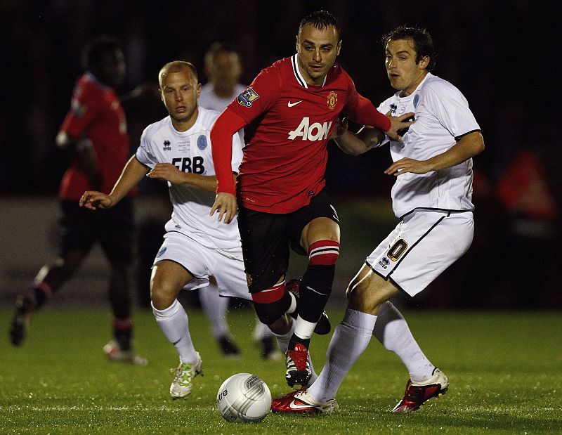 Danny Hylton, del Aldershot Town de cuarta división inglesa, disputa el balón con Berbatov, del Manchester United.
