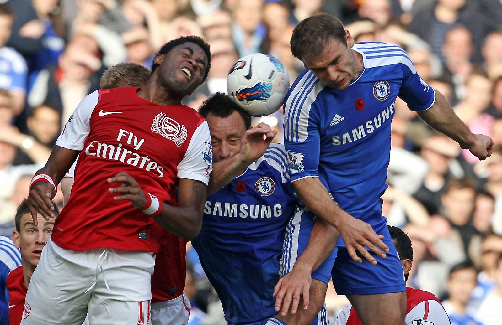 Los jugadores del Arsenal y del Chelsea pelean por un balón.