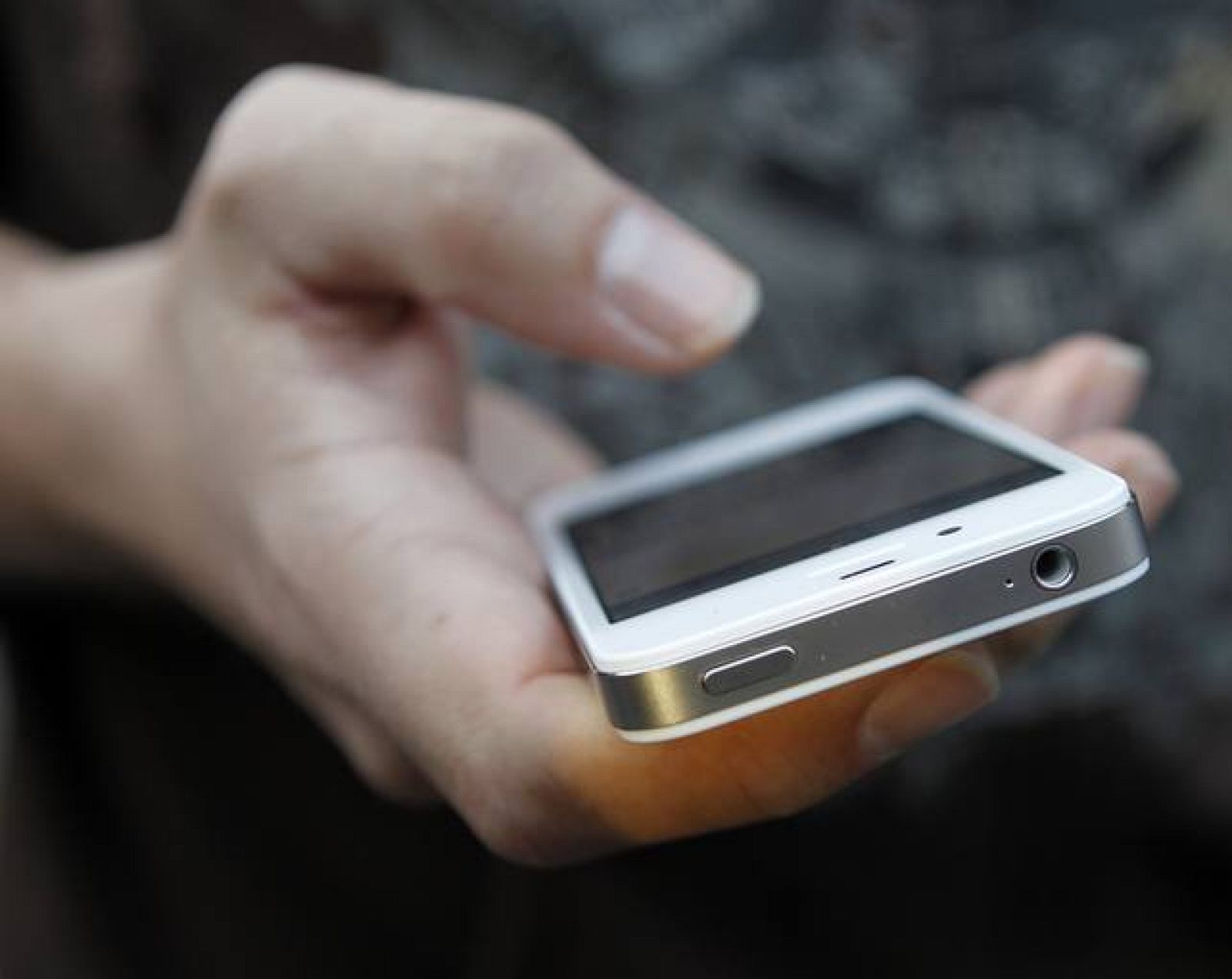 A customer uses his new iPhone 4S after making the purchase at Apple's flagship retail store in San Francisco