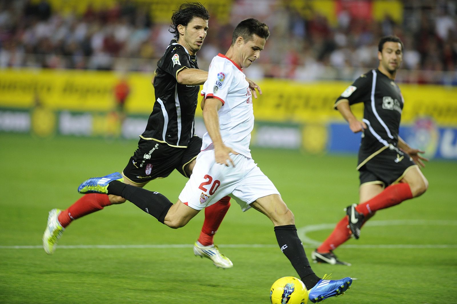 El jugador del Sevilla, Manu del Moral, pelea un balón con Diego Mainz, del Granada