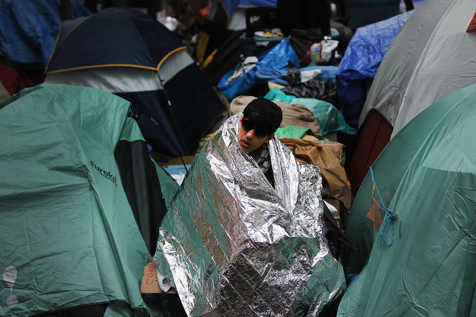 Un miembro del movimiento 'Occupy Wall Street' se refugia del frio de los últimos días en Nueva York