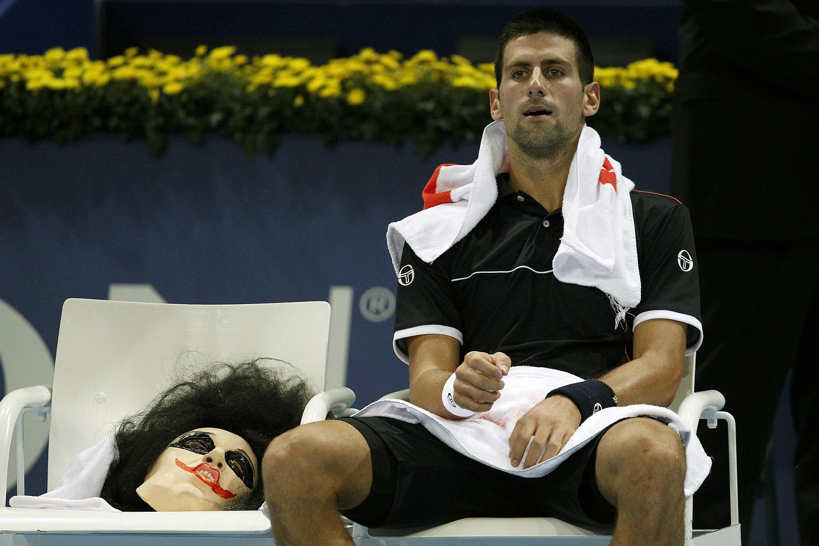 Djokovic, sentado en el partido, junto a una máscara de Halloween.