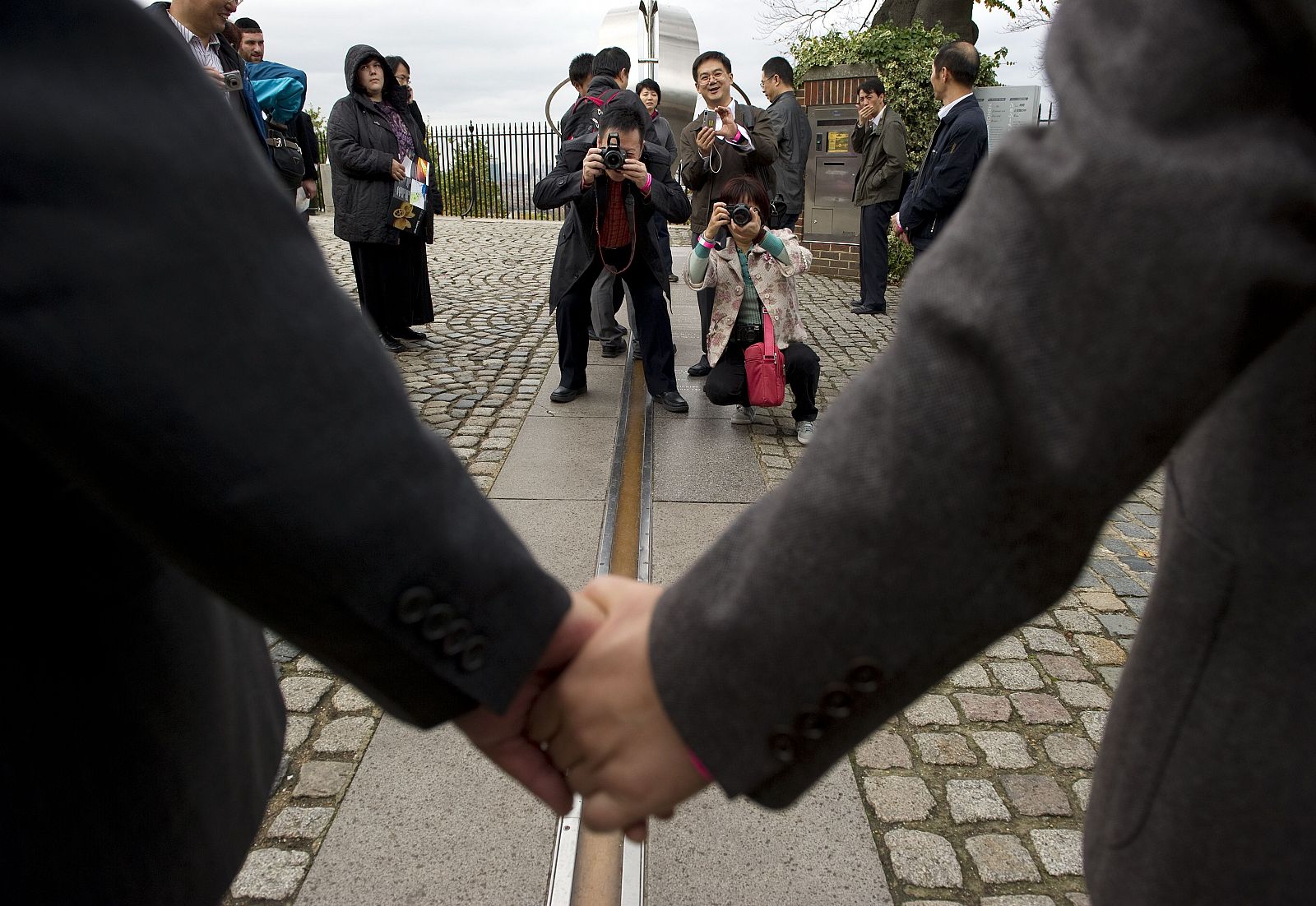 Unos turistas en el Real Observatorio de Greenwich, donde se encuentra marcado el meridiano que rige la hora GMT.