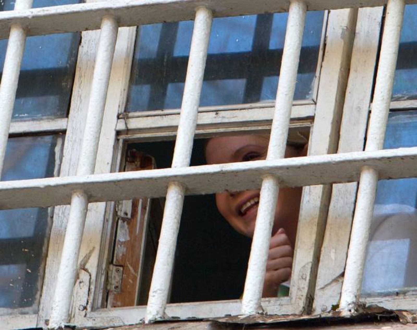 La ex primera ministra ucraniana, Yulia Tymoshenko, saluda tras las rejas de la prisión