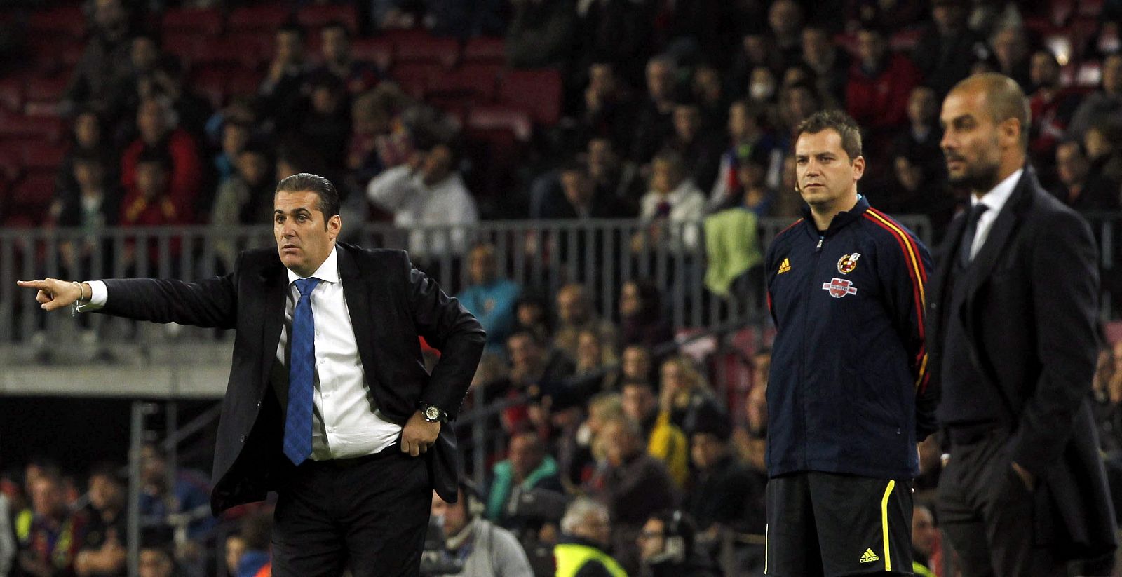 Los entrenadores del Rayo Vallecano José Ramón Sandoval (i) y del FC Barcelona Pep Guardiola, siguen desde la banda el partido.