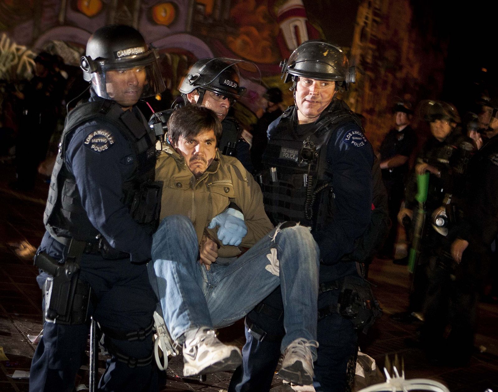 Policías de Los Ángeles desalojan a uno de los manifestantes que ocupaban el parque frente al Ayuntamiento