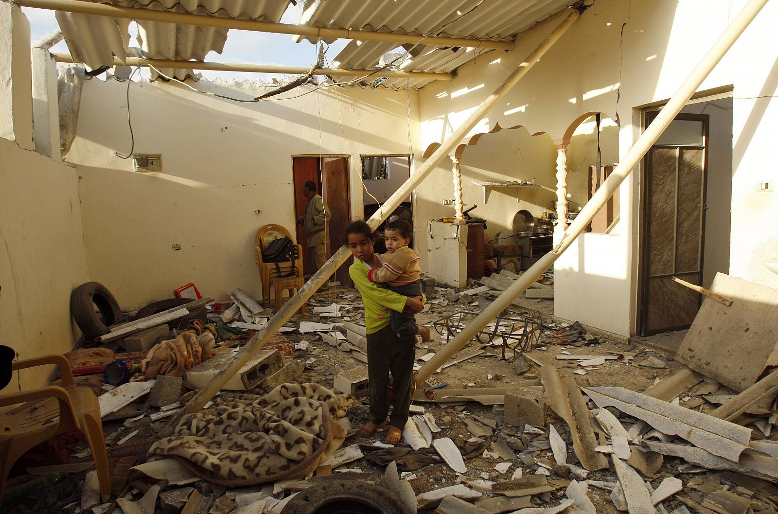 Una niña palestina y su hermano, en su casa de Gaza alcanzada por los bombardeos israelíes
