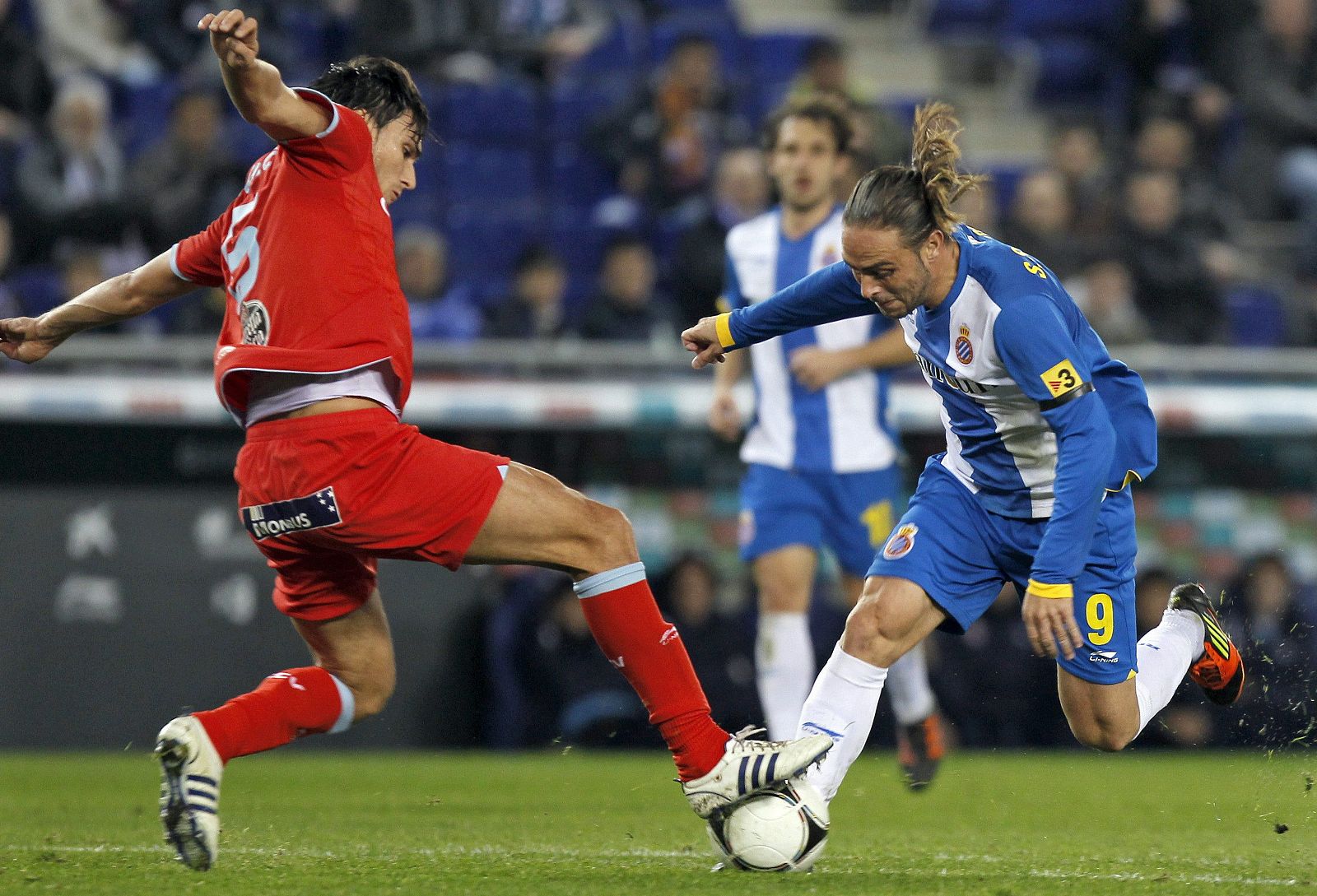 El delantero del RCD Espanyol Sergio García pelea un balón con el defensa del Celta de Vigo Jonathan Vila.