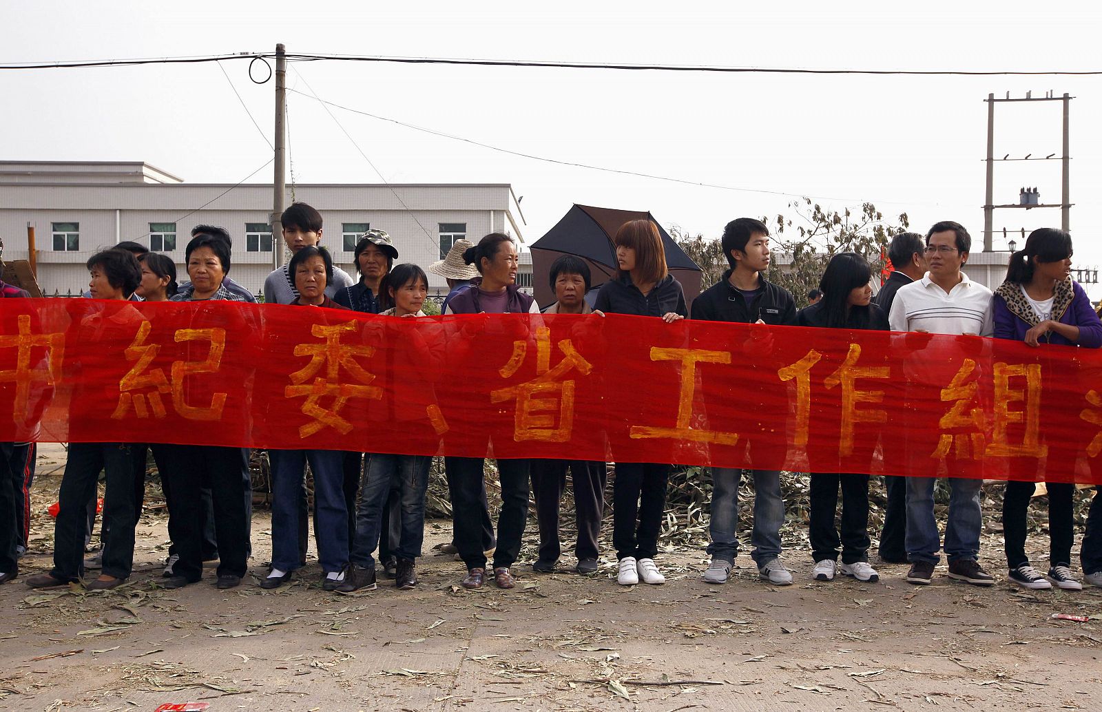 Vecinos de Wukan (China) con una pancarta esperan a los representantes del gobierno regional que negocian una solución al conflicto