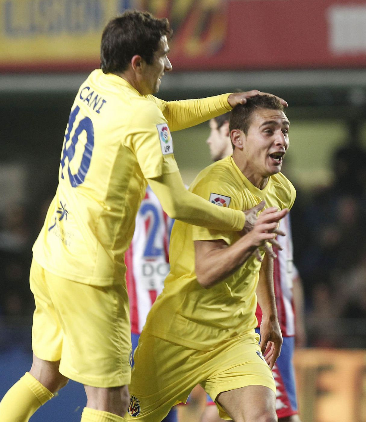 El delantero argentino del Villarreal Marco Rubén es felicitado por Cani tras marcar el primer gol ante el Sporting de Gijón.