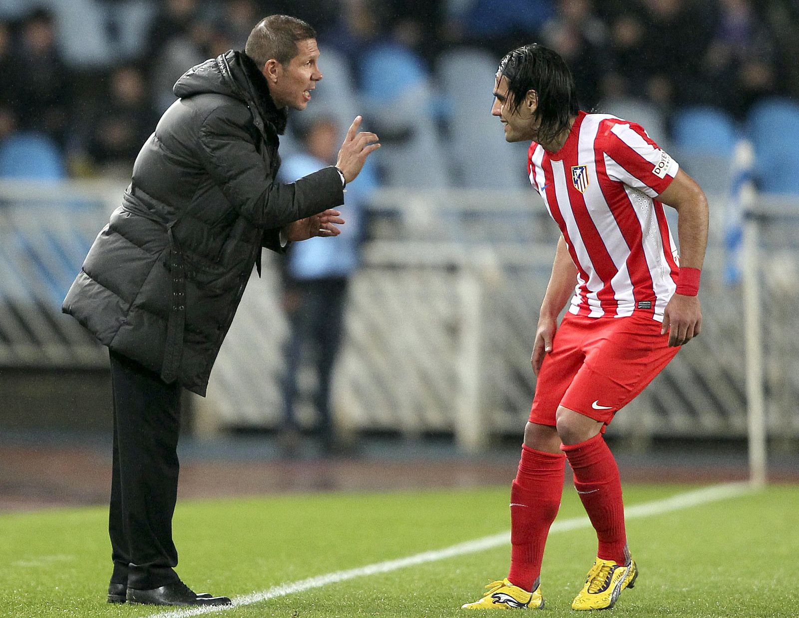 El entrenador del Atlético de Madrid, Diego "Cholo" Simeone (i), da instrucciones al delantero colombiano Radamel Falcao.