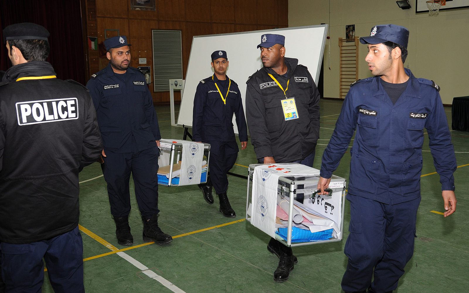 Oficiales de la policía kuwaití transporta urnas hacia la Asamblea Nacional