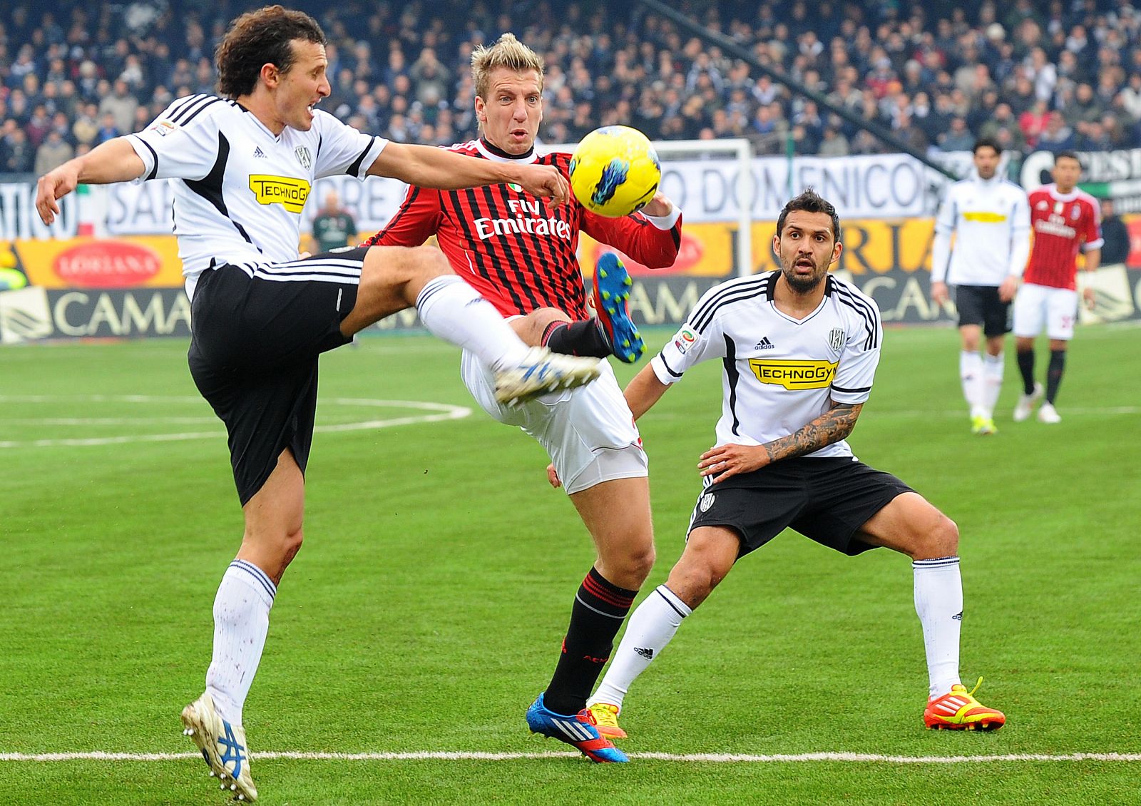 El jugador del Milan, Maxi Lopez, pelea un balón con Gianluca Comotto, del Cesena