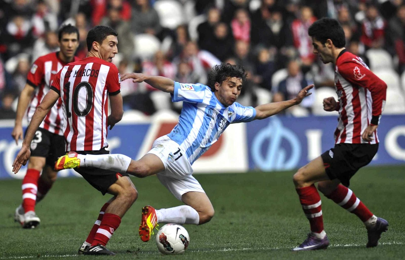 El delantero del Málaga Seba Fernández (c) cae ante Óscar de Marcos (i) y Markel Susaeta.