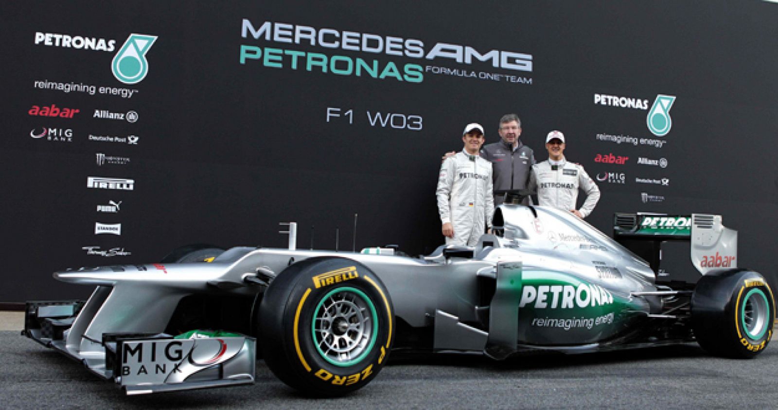 Los pilotos alemanes del equipo Mercedes GP, Michael Schumacher (d), y Nico Rosberg (i), y el propietario de la escuderia, Ross Brawn (c), posan ante el F1 W03, el nuevo monoplaza de la escuderia germana.