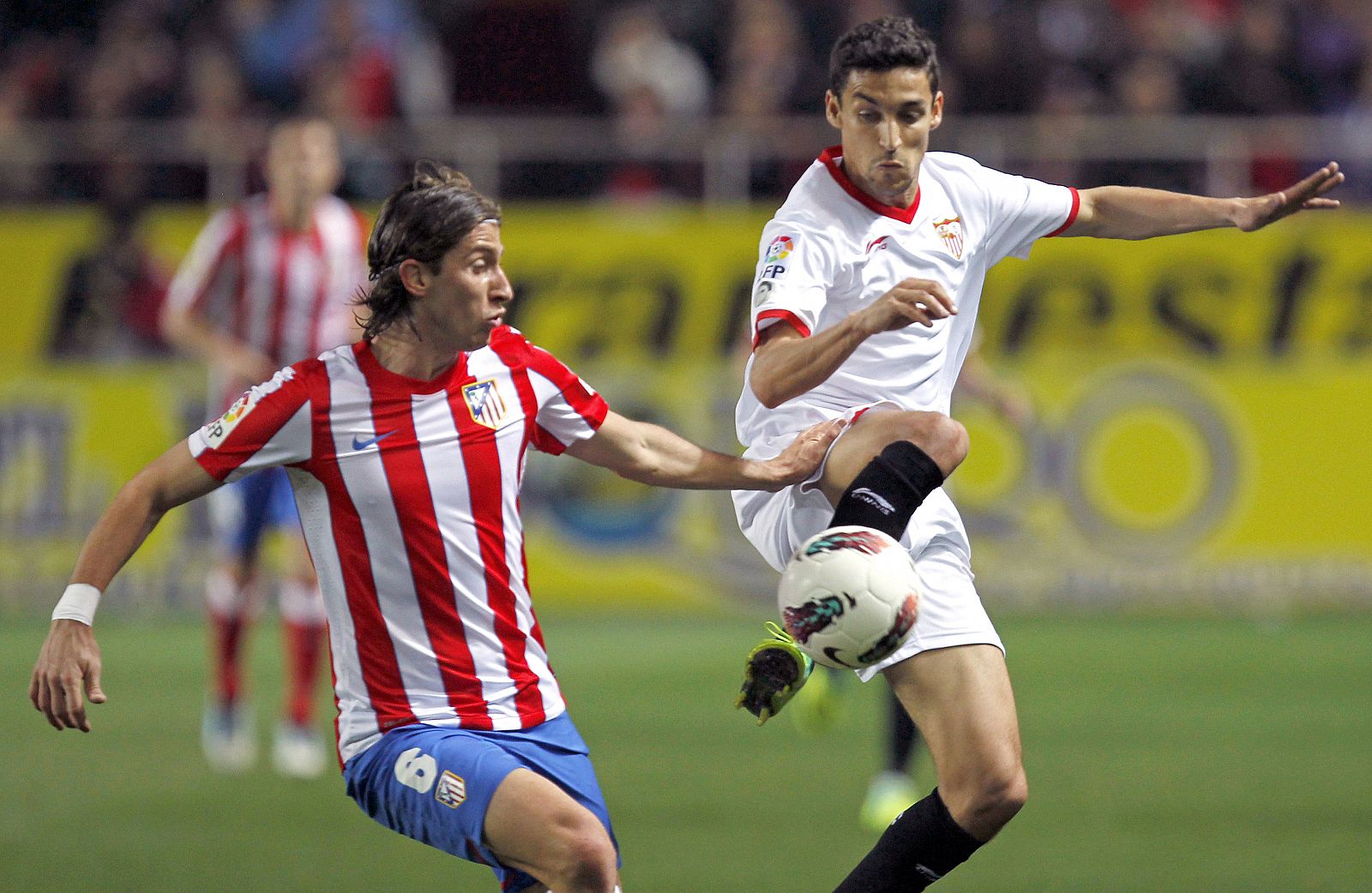 El delantero del Sevilla CF, Jesús Navas (d), lucha el balón con el brasileño Filipe Luis