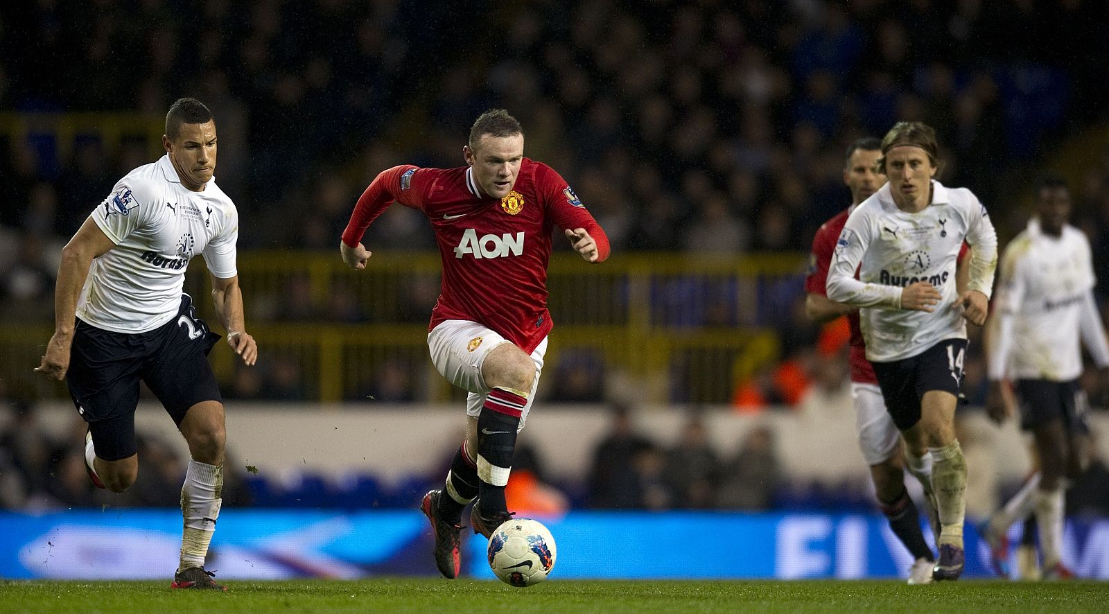 Rooney, del Manchester United, conduce el balón entre Livemore y Modric, del Tottenham