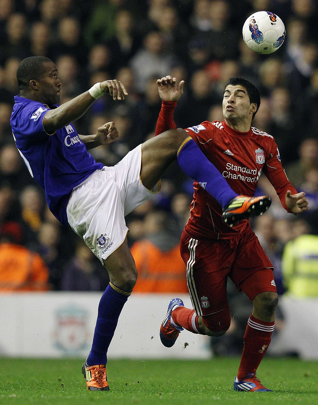 Liverpool's Suarez is challenged by Everton's Distin during their English Premier League soccer match in Liverpool