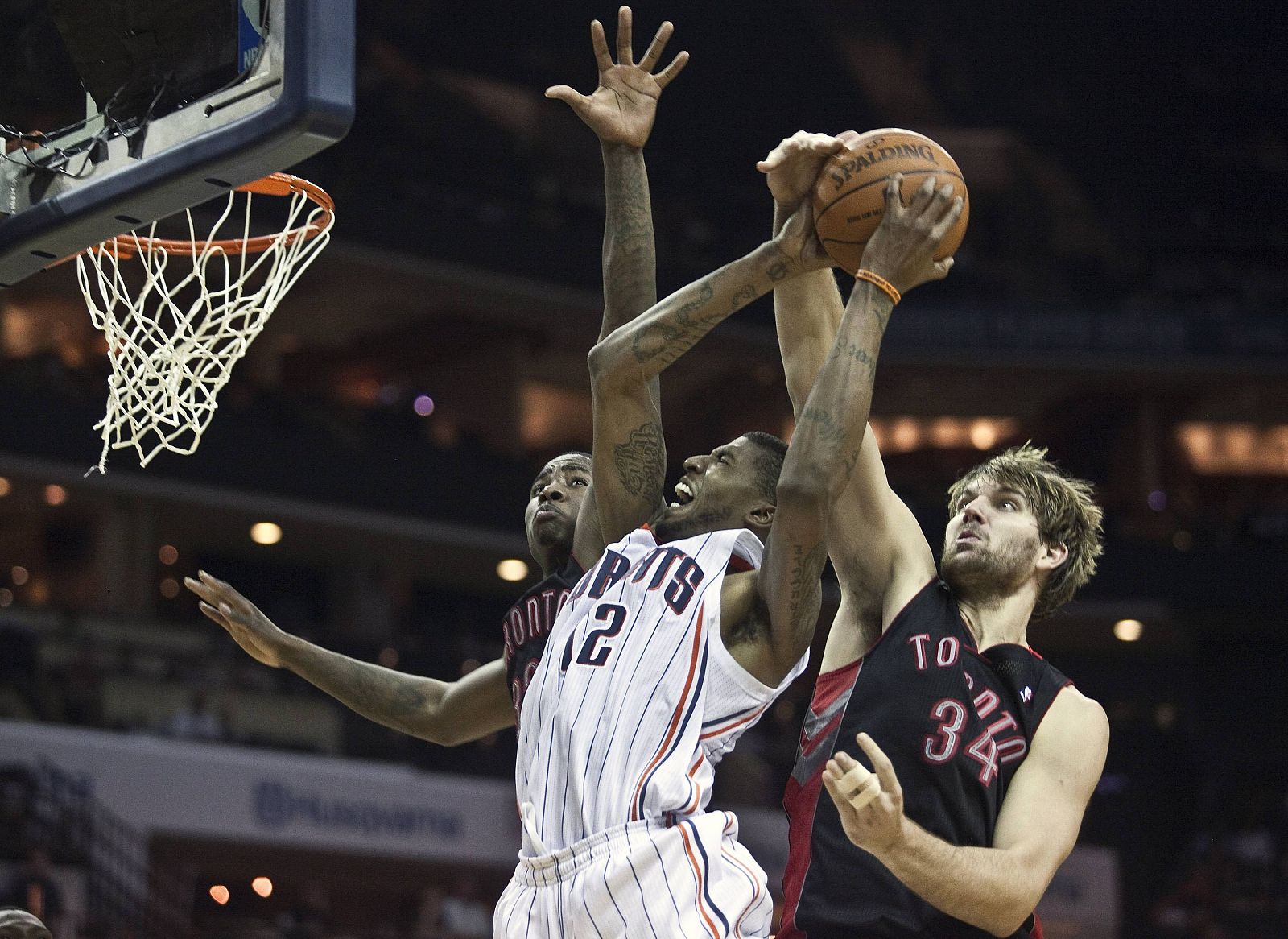 Charlotte Bobcats' Thomas goes up for a layup against Toronto Raptors' Gray and Davis during an NBA basketball game in Charlotte